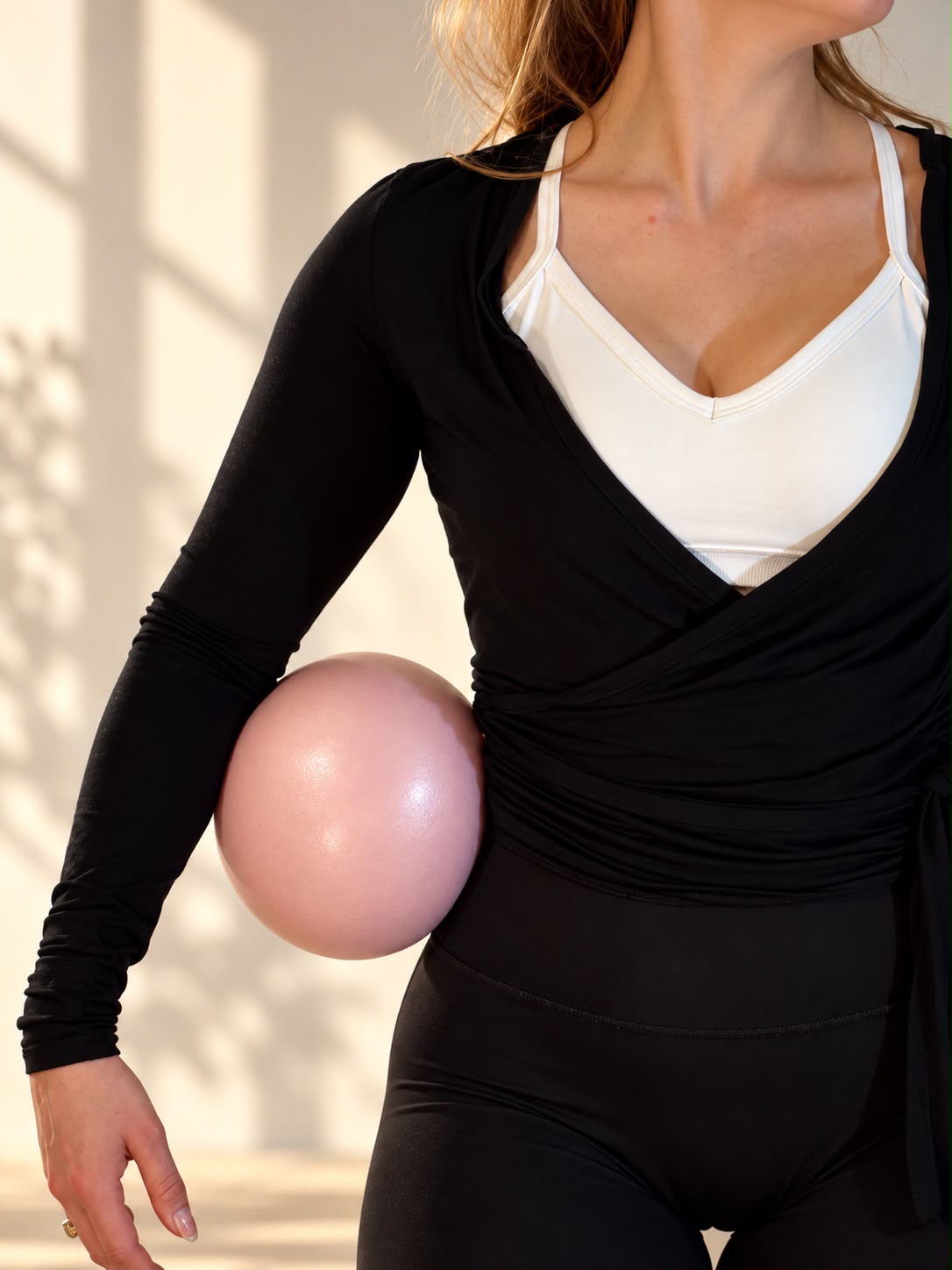 Pilates-Ball an der Taille gehalten