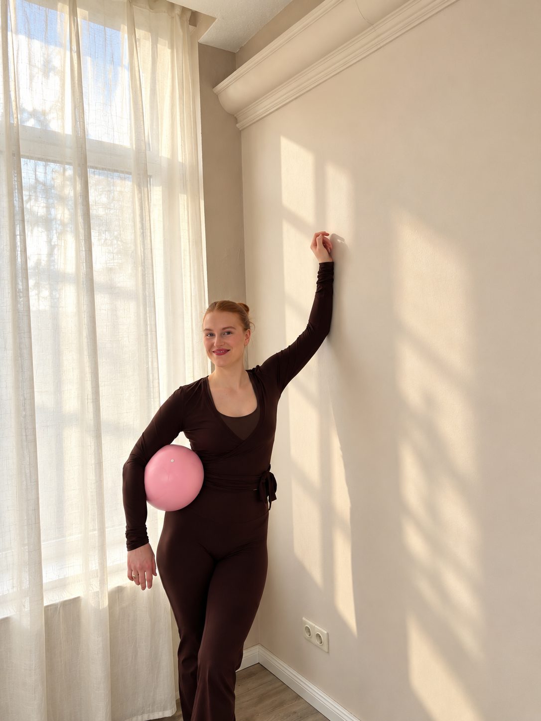 Stehend am Fenster mit Pilates-Ball