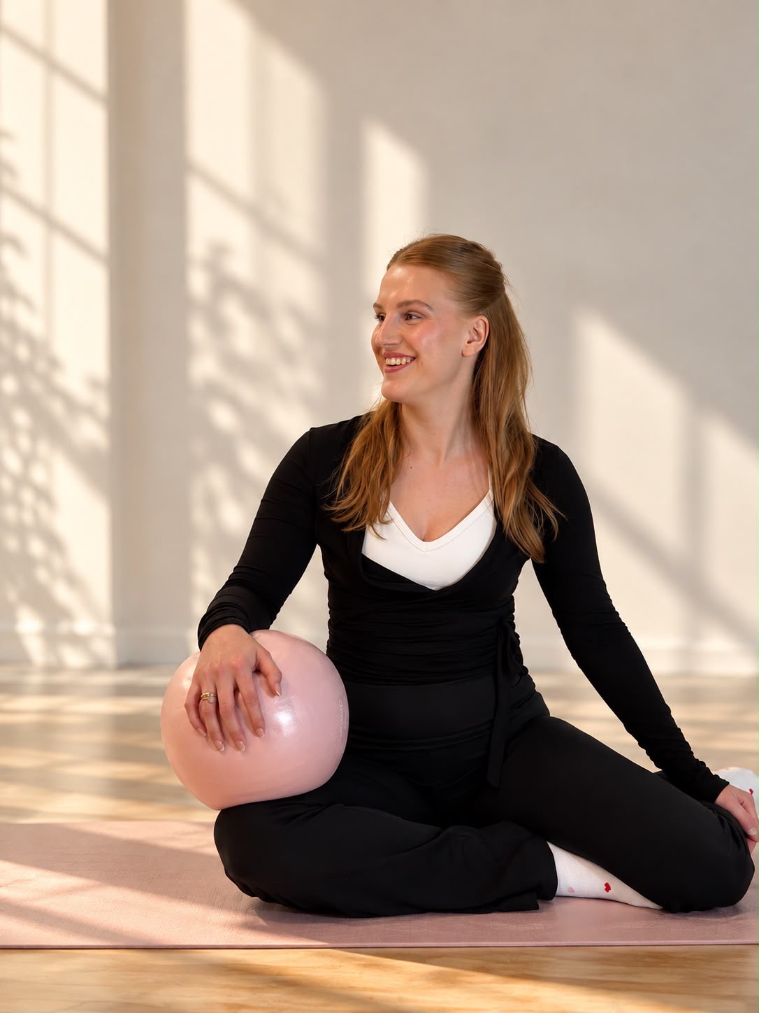 Schneidersitz mit Ball in den Händen