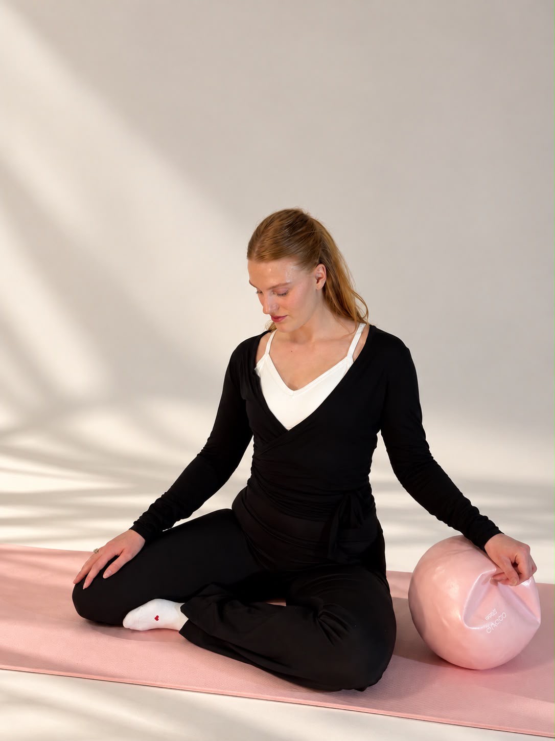 Ruhige Sitzhaltung mit der Hand auf dem Pilates-Ball